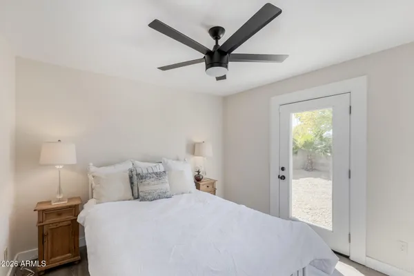 an empty room with a window and a fan