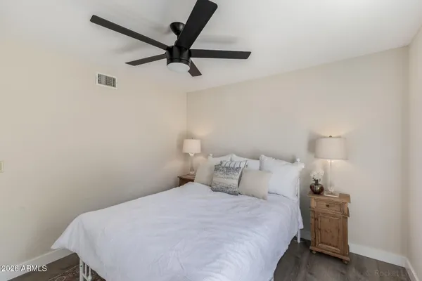 an empty room with wooden floor closet and windows