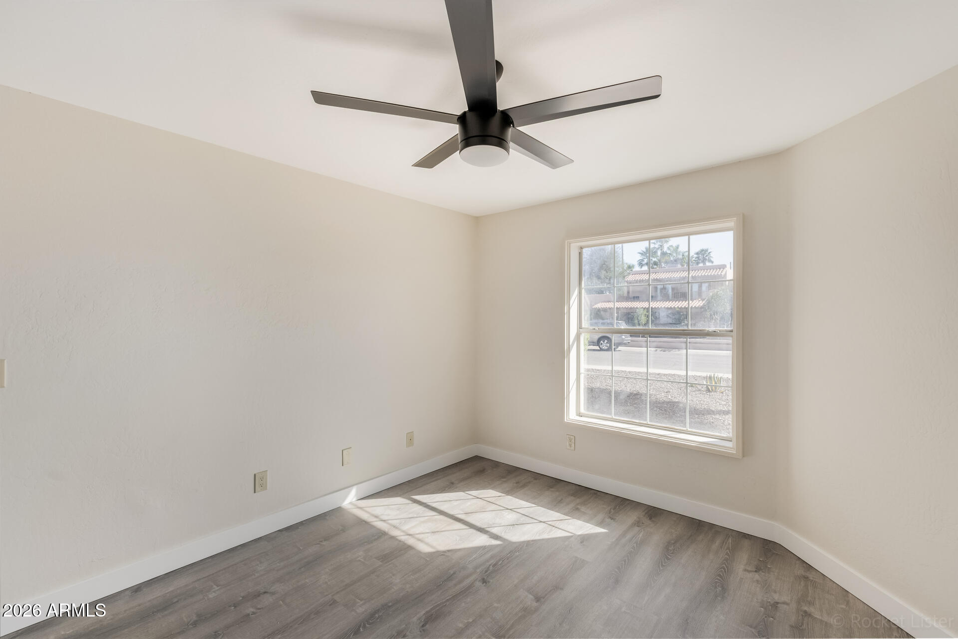 5116 East Wethersfield Road Scottsdale, AZ 85254 - Photo 32 of 53 an empty room with a ceiling fan and windows