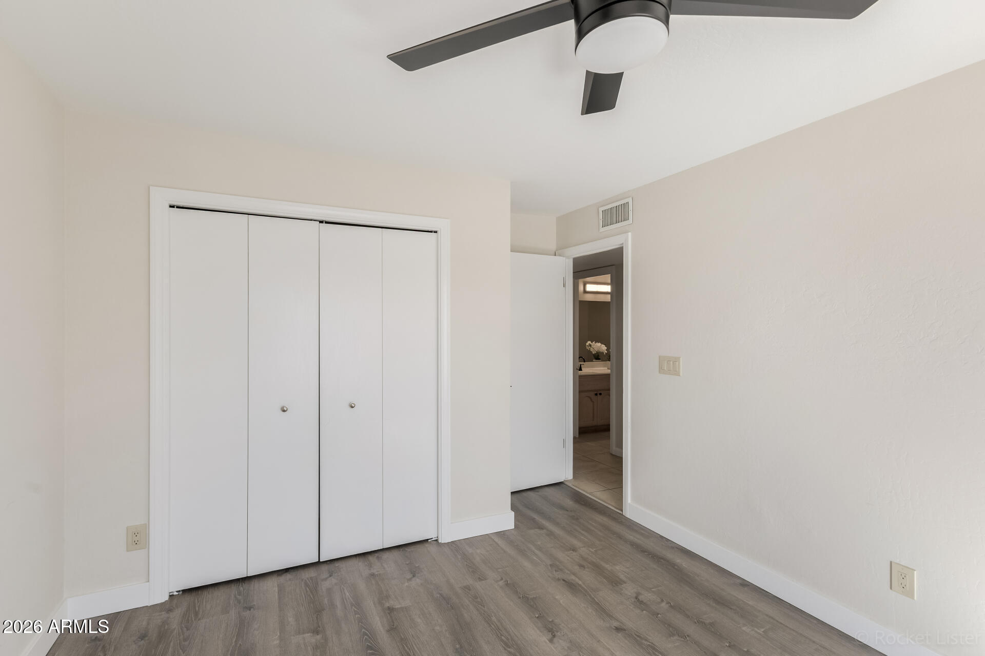 5116 East Wethersfield Road Scottsdale, AZ 85254 - Photo 34 of 53 an empty room with wooden floor closet and windows