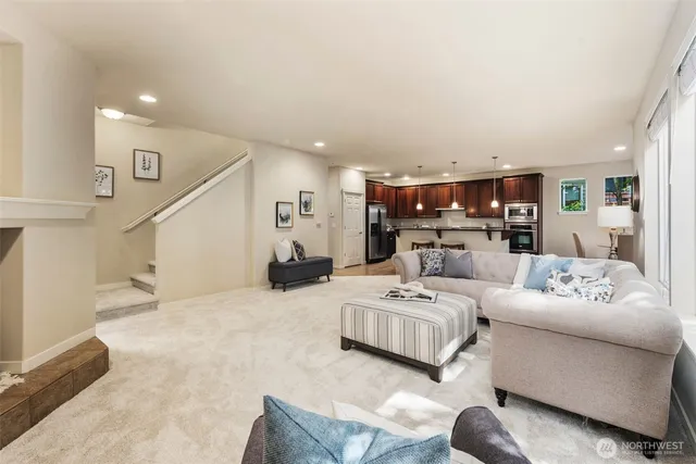 a living room with furniture and a view of kitchen