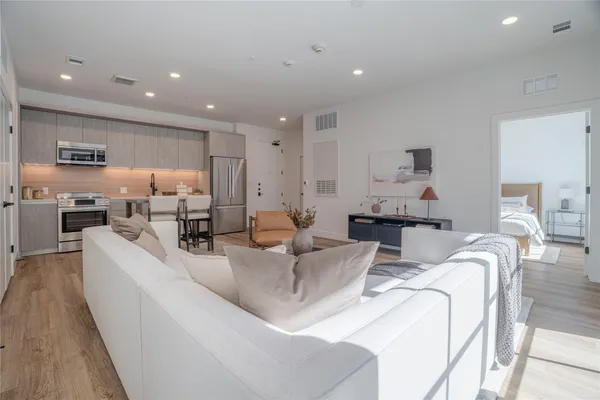 a living room with furniture and a wooden floor