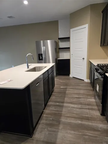 a kitchen with stainless steel appliances granite countertop a sink stove and refrigerator