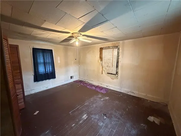 an empty room with windows and cabinet
