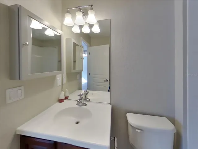 a bathroom with a sink a toilet and a mirror