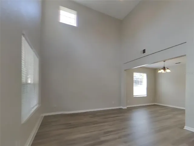 a view of empty room with window and wooden floor