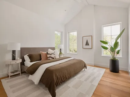 a bedroom with a balcony a large bed and a window