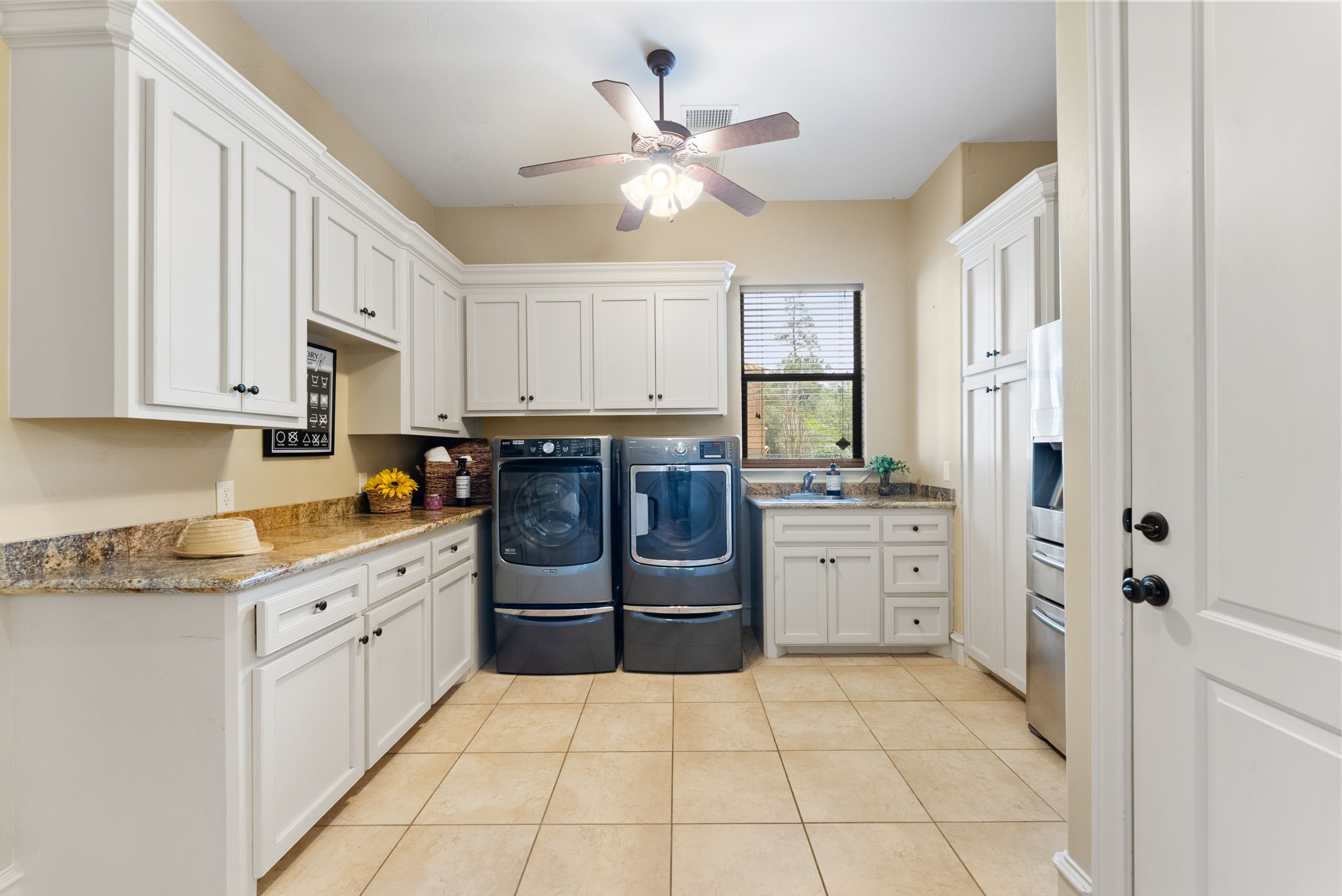 3907 Rayford Road Spring, TX 77386 - Photo 23 of 38 Perfectly located off the garage entry, this oversized Utility Room offers walls of built-ins, granite countertops for workspace, a utility sink with a window overlooking the driveway, and space for an additional refrigerator.