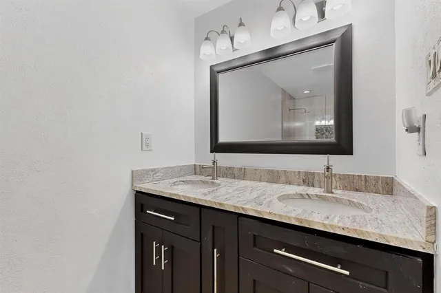 a bathroom with a granite countertop sink a double vanity and a mirror