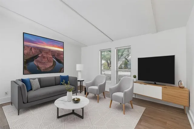a living room with furniture a rug and a flat screen tv