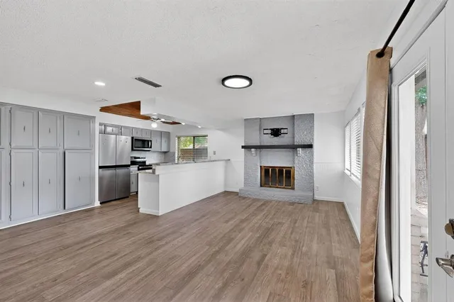 a open kitchen with a refrigerator and a stove top oven