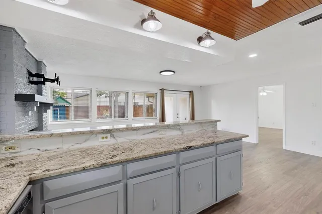 a kitchen with granite countertop sink and cabinets