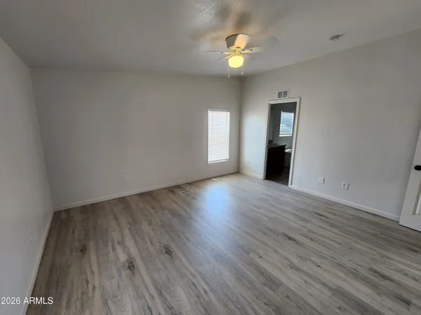 a view of empty room with wooden floor