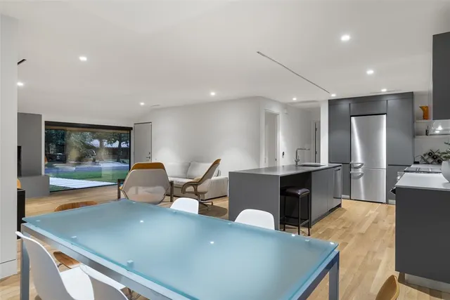 a view of a dining room with furniture a kitchen and chandelier