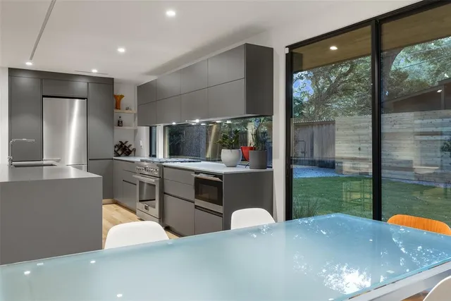 a kitchen with kitchen island a counter top space a sink stainless steel appliances and cabinets