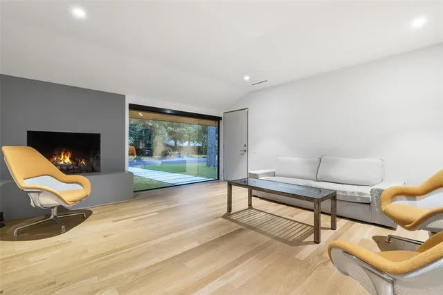 a living room with furniture a flat screen tv and a floor to ceiling window