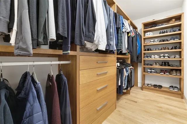 a view of walk in closet with clothes and shoes