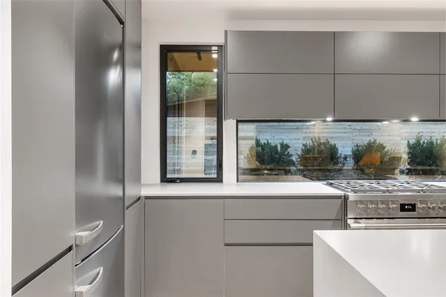 a kitchen with stainless steel appliances granite countertop a stove a sink and a refrigerator