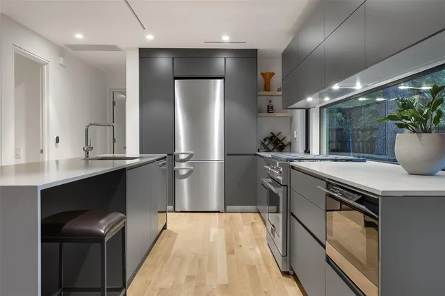 a kitchen with stainless steel appliances a sink stove and refrigerator