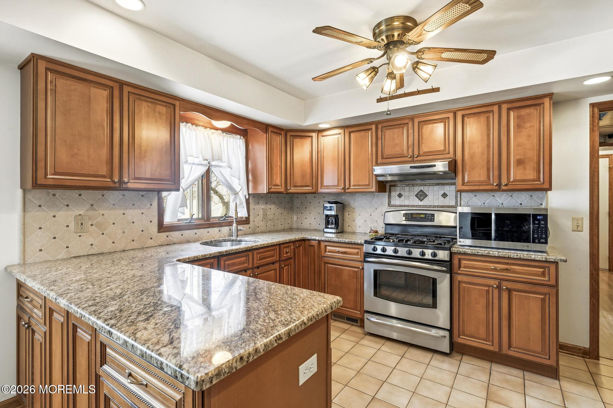 100 Sheldon Avenue Neptune Township, NJ 07753 - Photo 19 of 75 a kitchen with kitchen island granite countertop a stove sink and cabinets