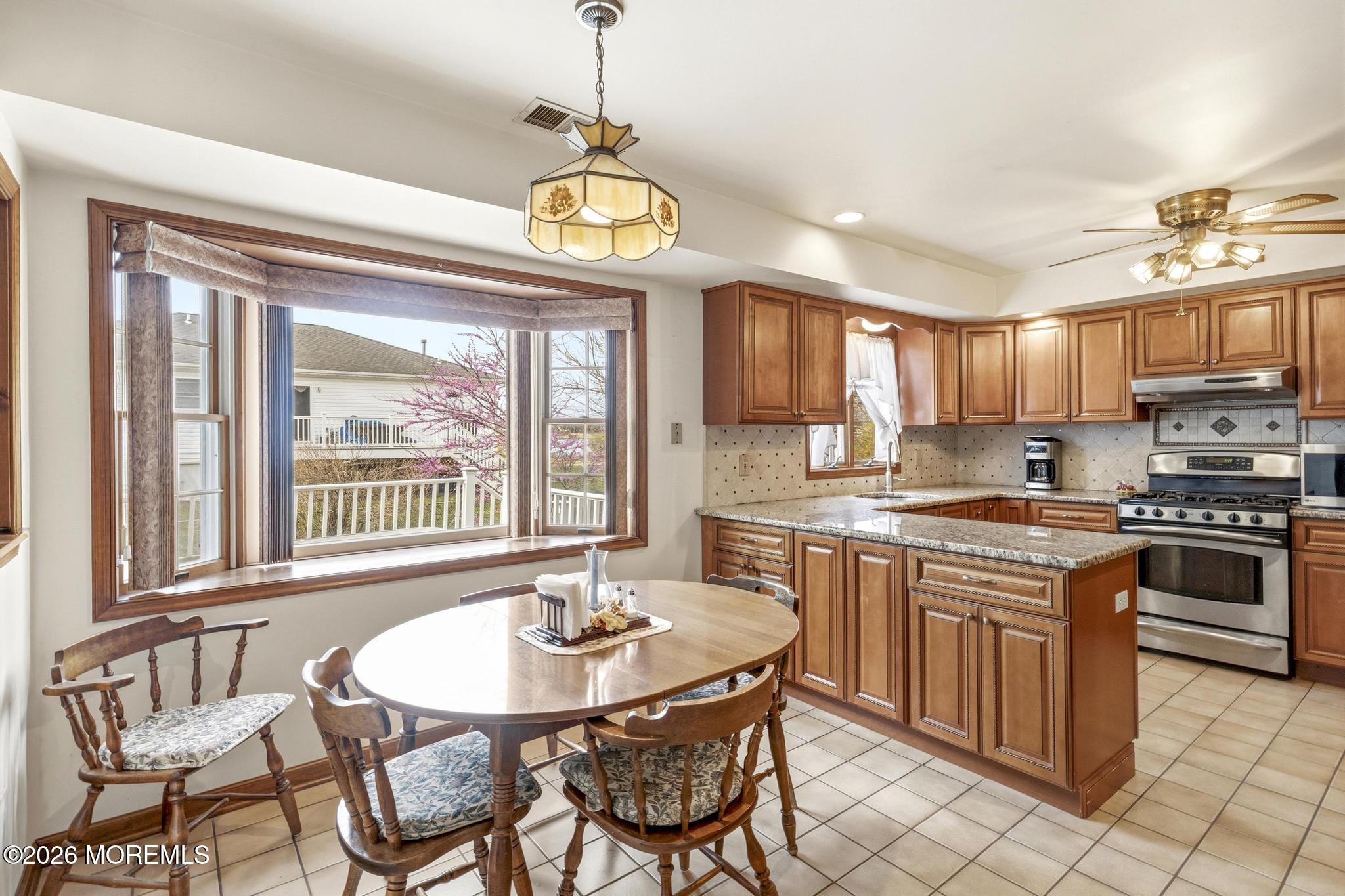 100 Sheldon Avenue Neptune Township, NJ 07753 - Photo 24 of 75 a kitchen with stainless steel appliances granite countertop a stove a sink a microwave oven a dining table and chairs with wooden floor