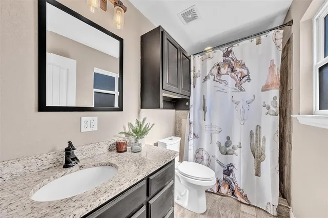 a bathroom with a granite countertop sink toilet and shower