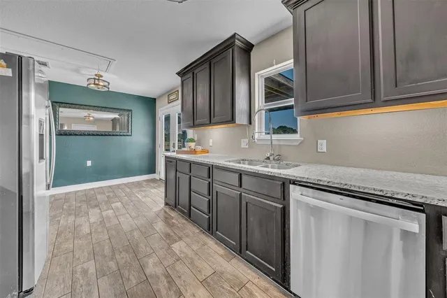 a kitchen with granite countertop a sink and cabinets