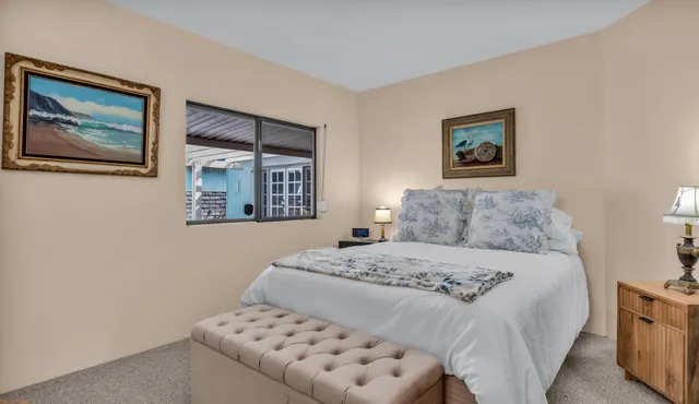 a bedroom with a bed and a painting on the wall