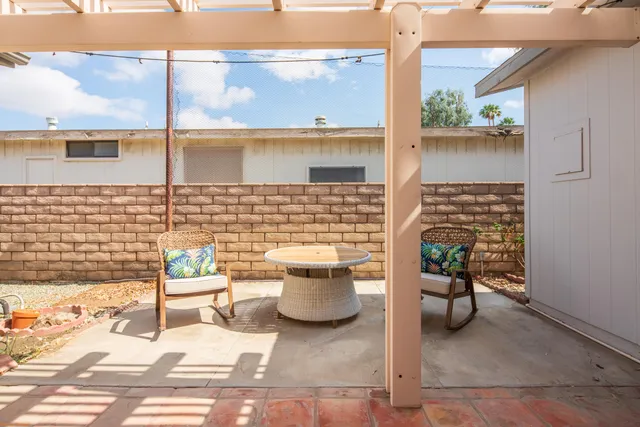 a view of a patio with a chairs and table potted plants