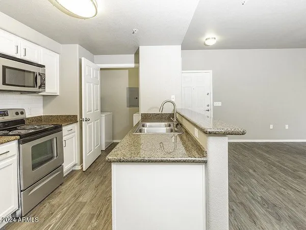 a kitchen with granite countertop a sink and a stove top oven