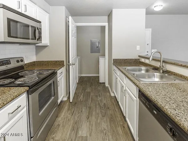 a kitchen with granite countertop a sink and steel appliances
