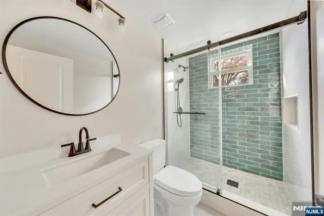 a bathroom with a sink a toilet and a mirror