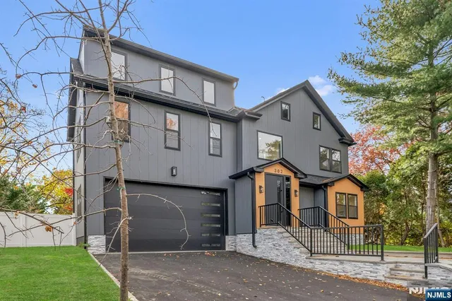 a view of a house with a yard and large tree