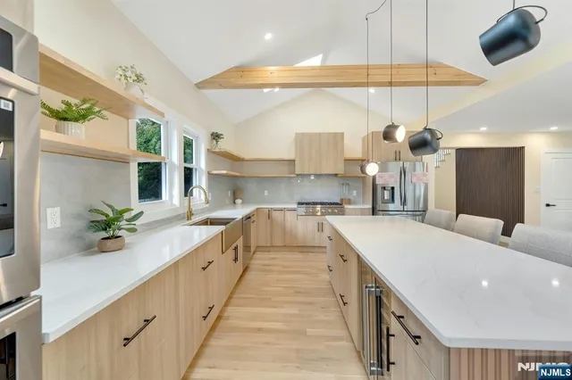 a large kitchen with stainless steel appliances kitchen island granite countertop a sink and cabinets