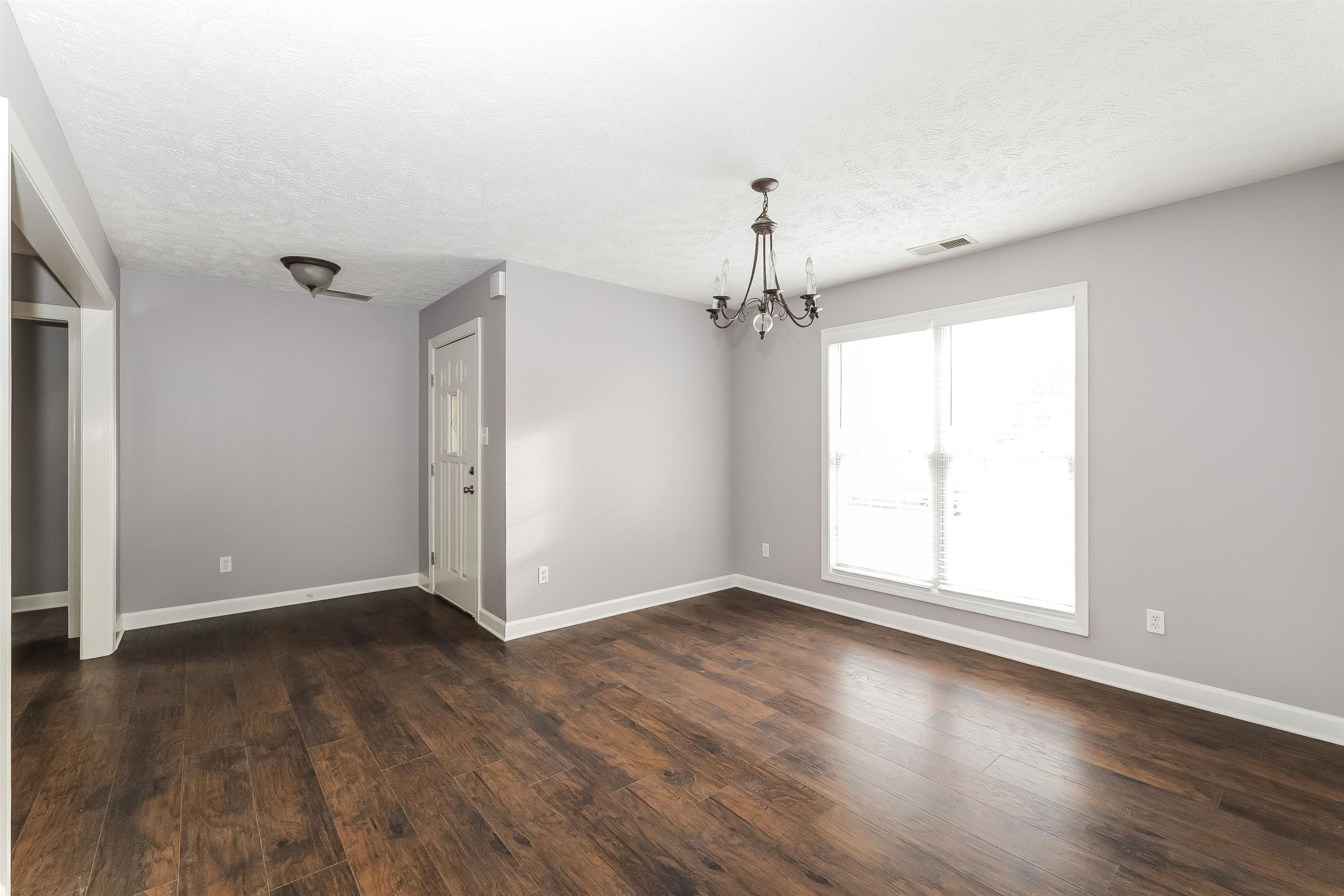 97 Jadewood Drive Jackson, TN 38305 - Photo 4 of 16 an empty room with wooden floor and windows