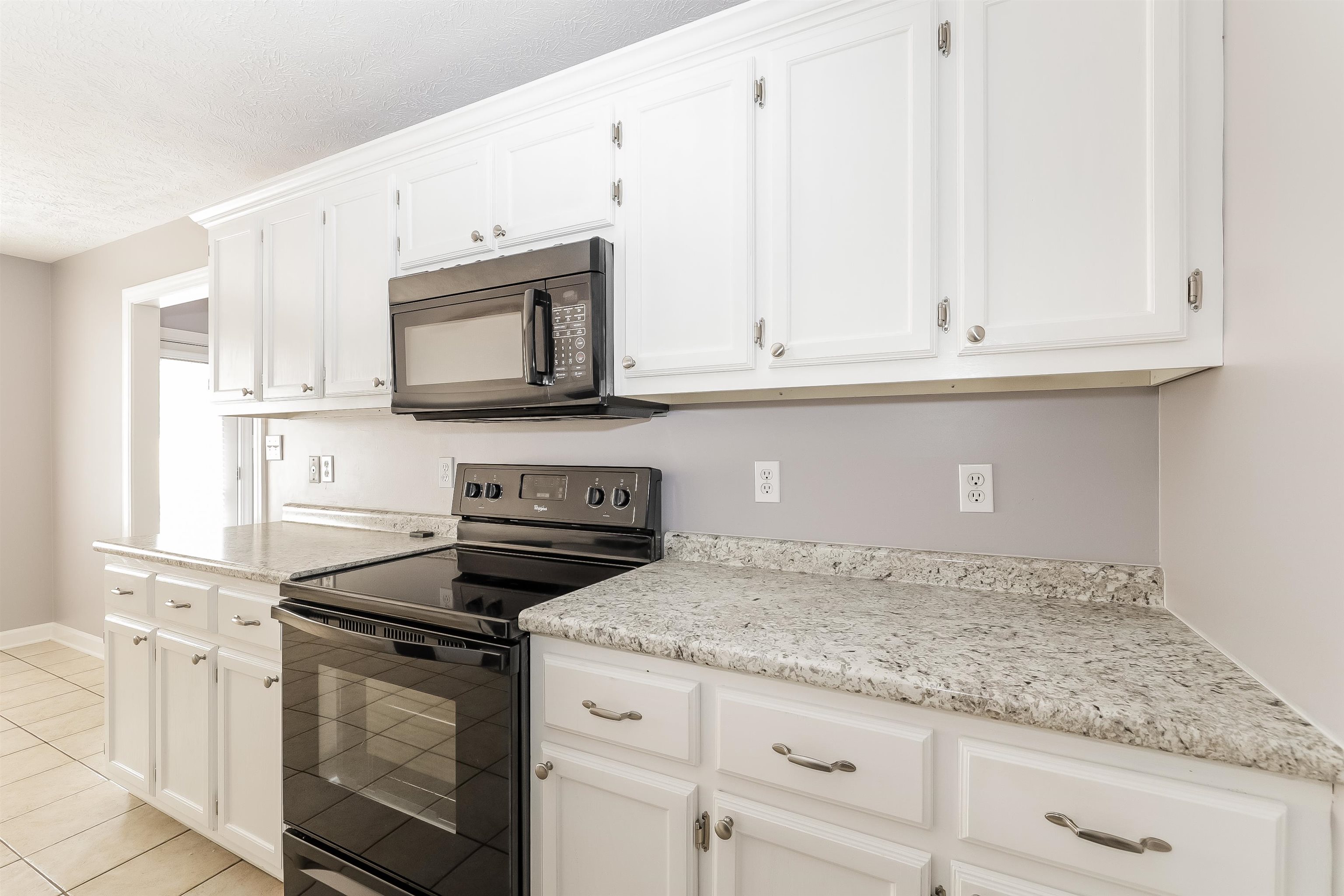 97 Jadewood Drive Jackson, TN 38305 - Photo 6 of 16 a kitchen with granite countertop white cabinets and stainless steel appliances