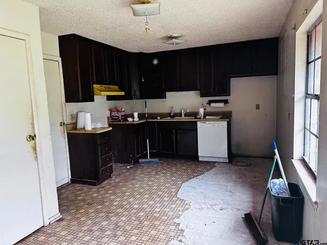 a kitchen with stainless steel appliances granite countertop a refrigerator stove top oven and sink