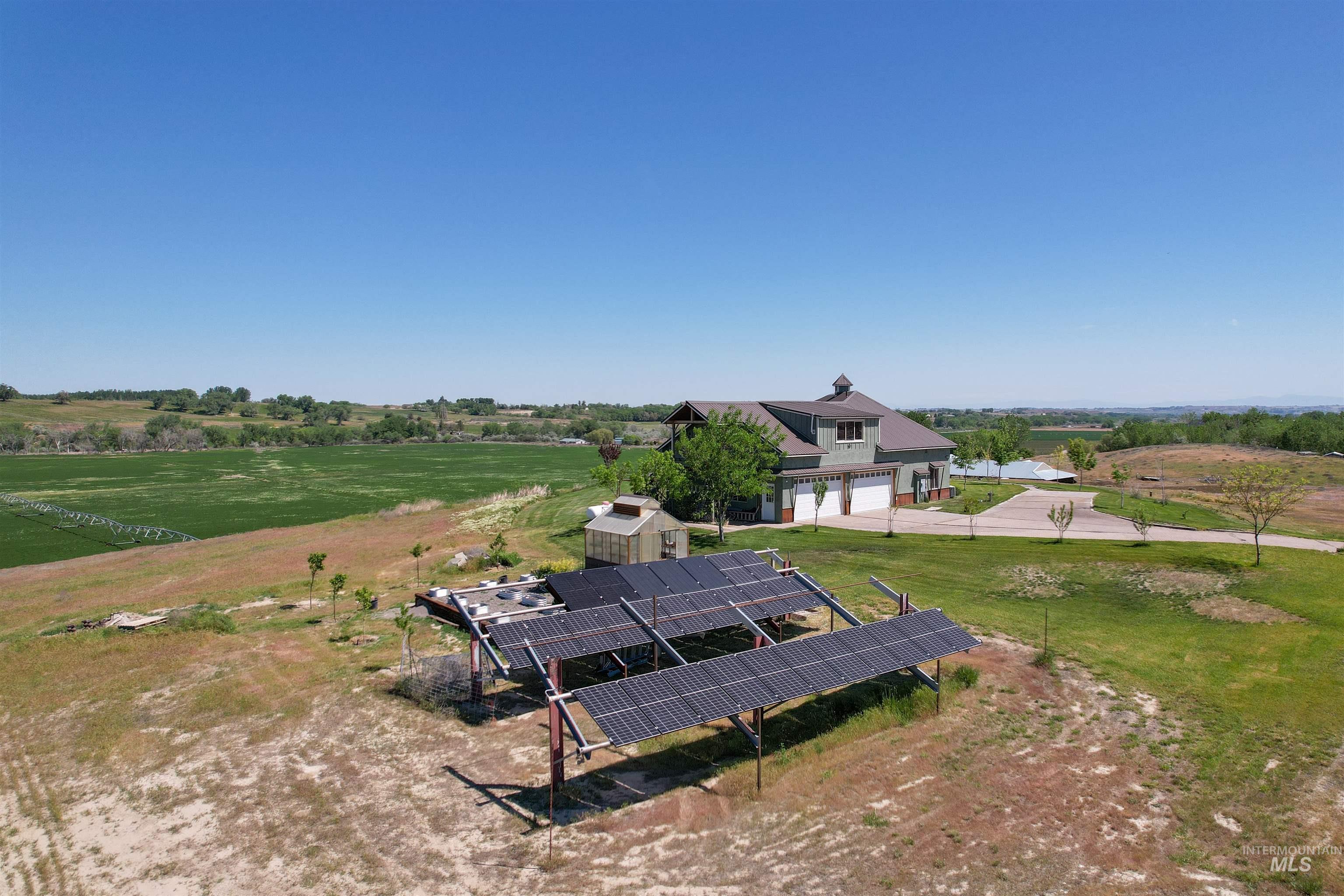 1030 Desert Glen Road Adrian, OR 97901 - Photo 6 of 47 Expansive multi-panel solar array with a secondary dwelling featuring a cupola, attached three-car garage, and a gravel driveway