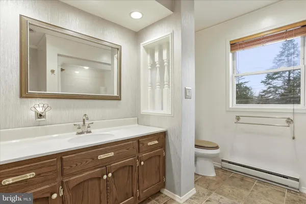 a bathroom with a toilet a sink a vanity and mirror