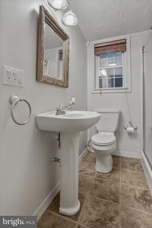 a bathroom with a toilet sink and mirror