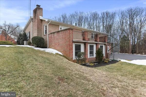 a front view of a house with yard and trees in the background