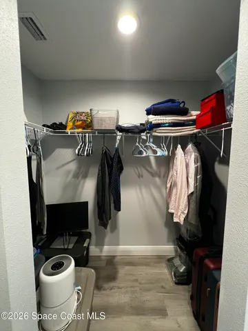a view of walk in closet with clothes and shoes