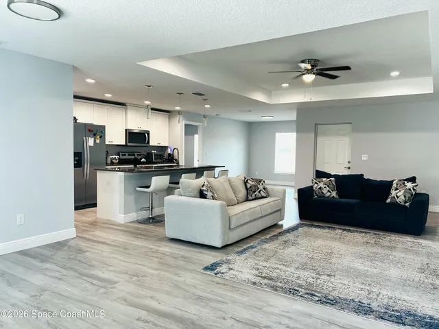 a living room with furniture and kitchen