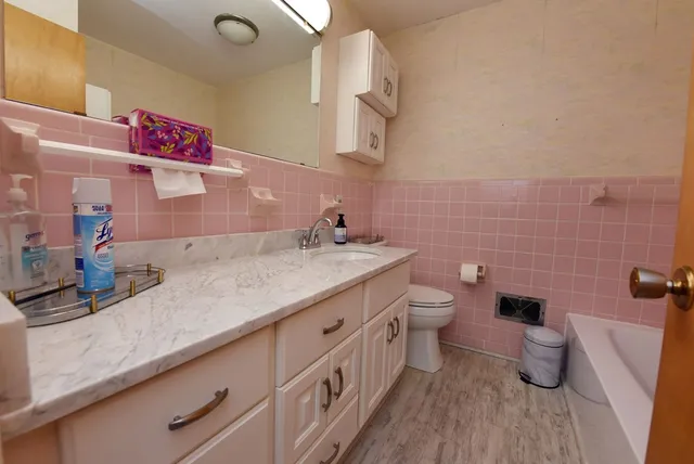 a bathroom with a granite countertop toilet sink and mirror