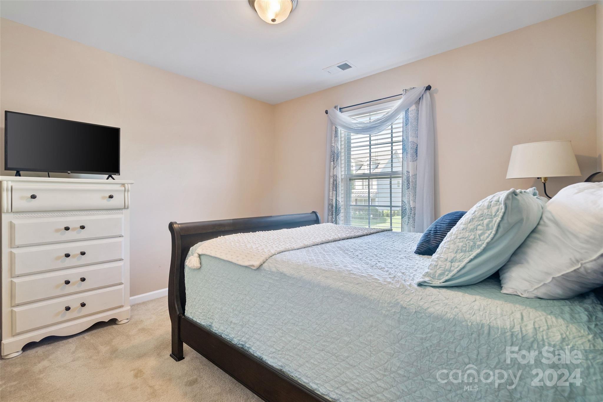 105 Annatto Way Fort Mill, SC 29708 - Photo 16 of 32 a bedroom with a bed and a flat tv screen on dresser