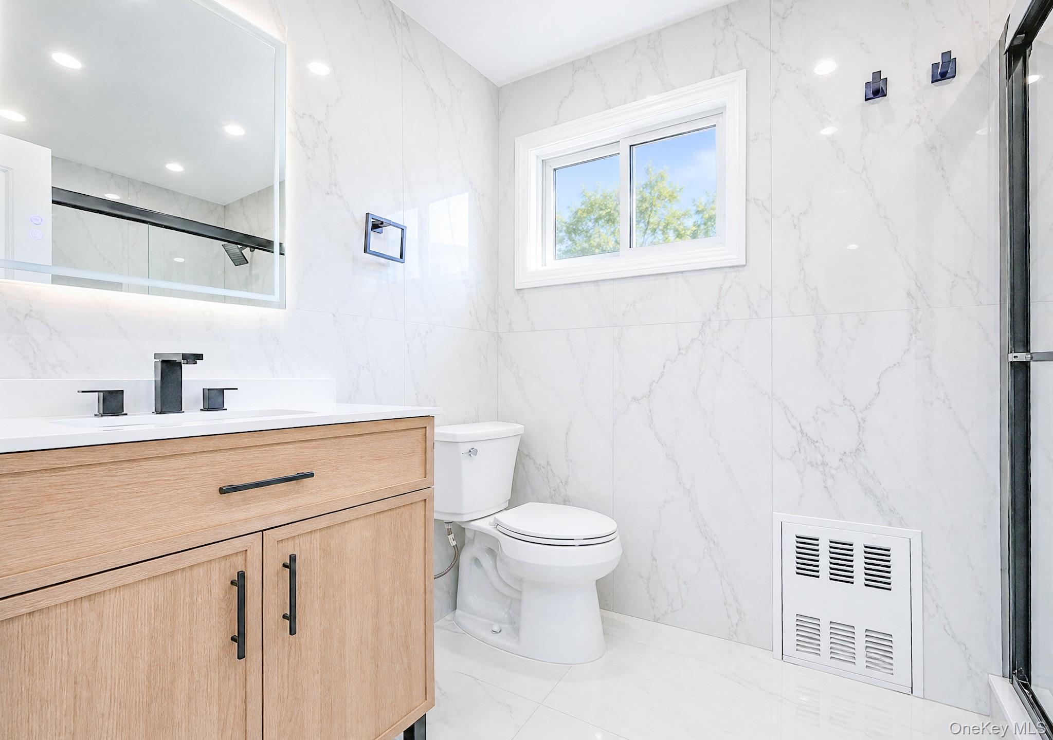61 Cheshire Road Bethpage, NY 11714 - Photo 12 of 25 Modern bathroom featuring a wood-finish vanity with a white countertop and matte black fixtures