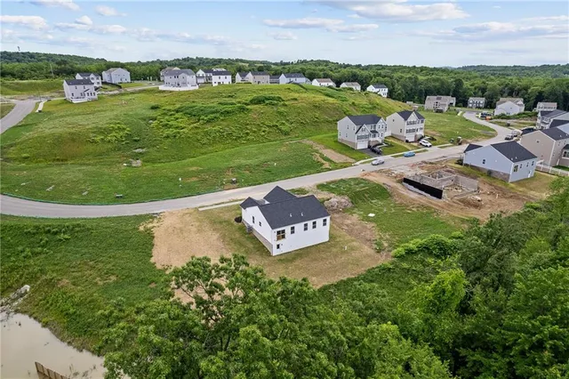 an aerial view of a house with a garden and lake view