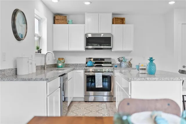a kitchen with stainless steel appliances granite countertop a sink a stove and a microwave