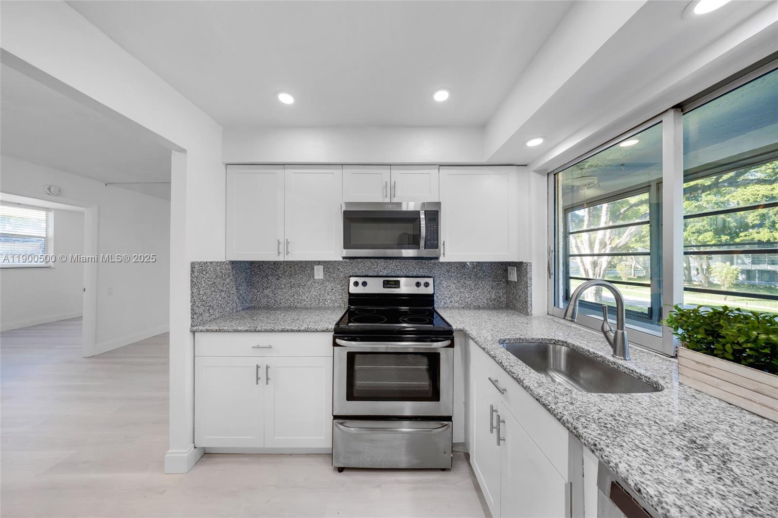 9090 Lime Bay Boulevard, Unit 211 Tamarac, FL 33321 - Photo 11 of 23 a kitchen that has a sink and a stove