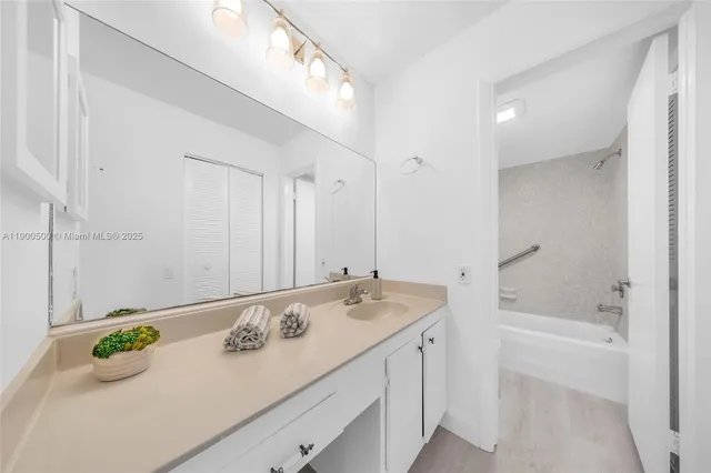 a bathroom with a granite countertop sink and a bathtub